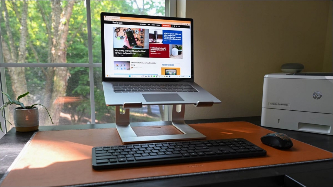 Работа на дому с ноутбуком Microsoft Surface, установленным на подставке для ноутбука с мышью и клавиатурой